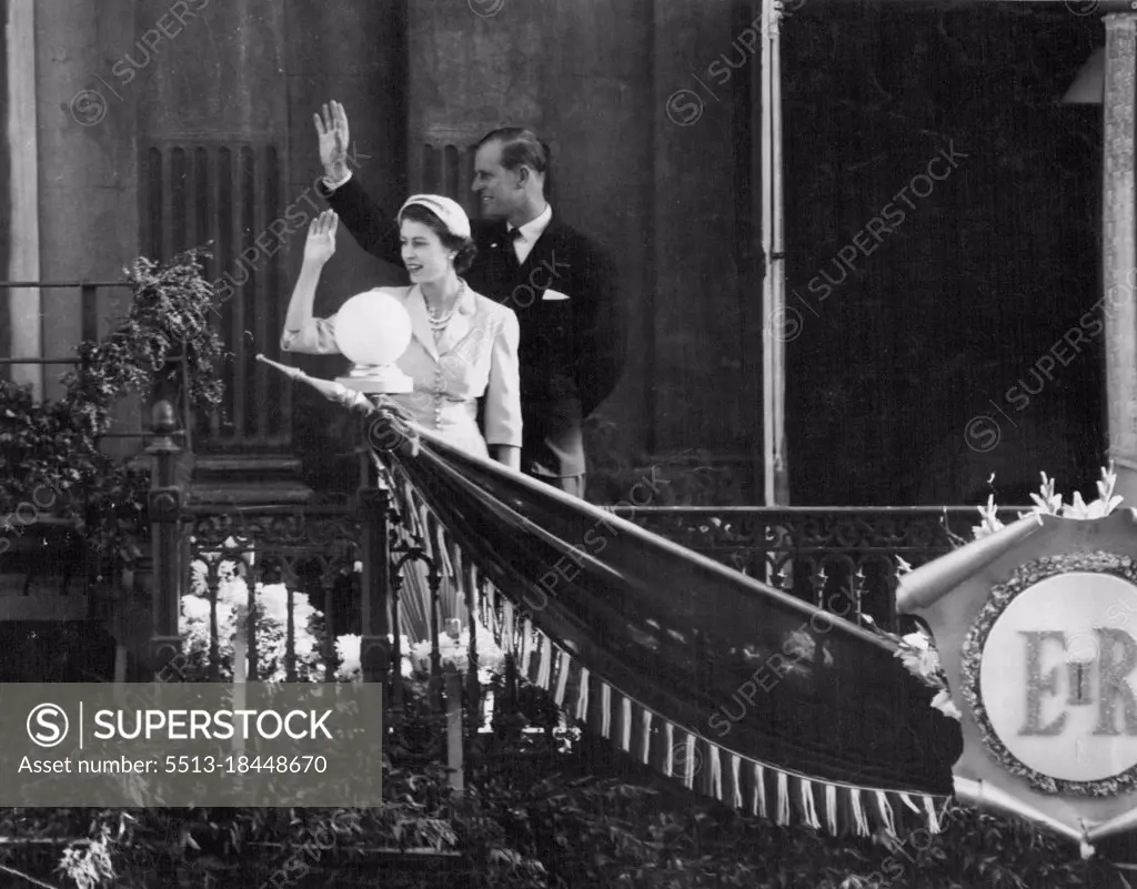 Queen Elizabeth and the Duke of Edinburgh wave to the crowd from the veranda of their hotel in Christchurch, which overlooks Cathedral Square. January 25, 1954.