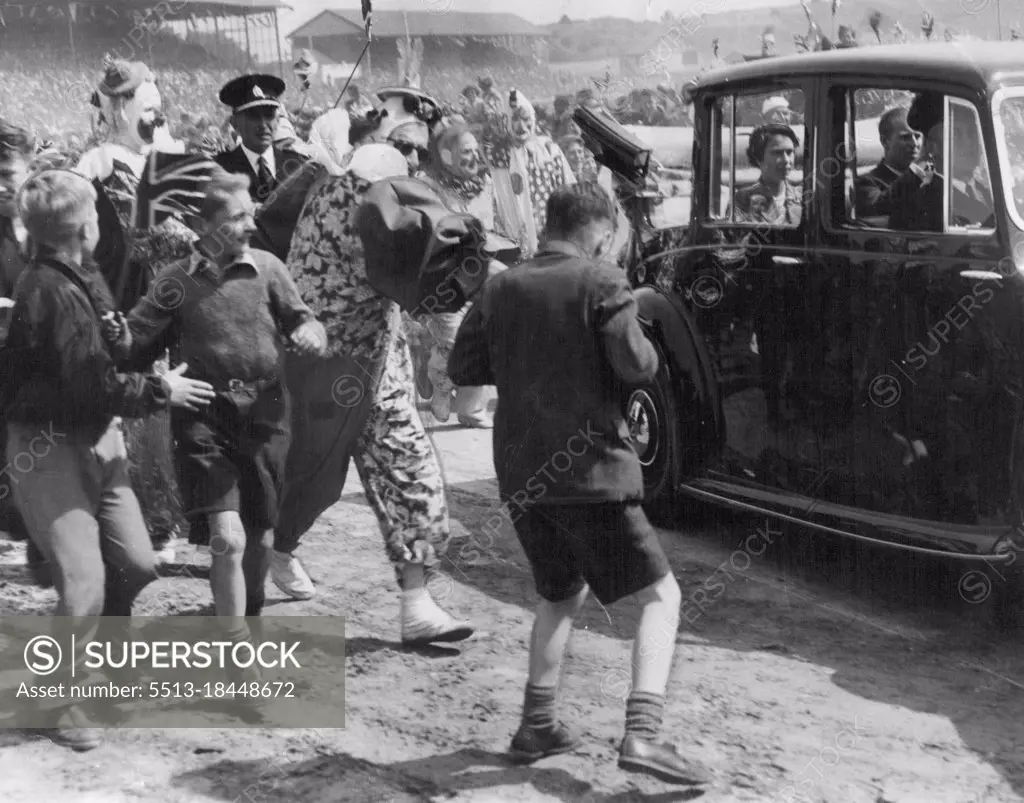 Dunedin (NZ) police had a hard task clearing the way for the Royal car, as children and adults mobbed it when the Queen and Duke of Edinburgh attended a reception. Clowns assisting in the entertainment at the reception helped police push back the crowd. January 30, 1954.