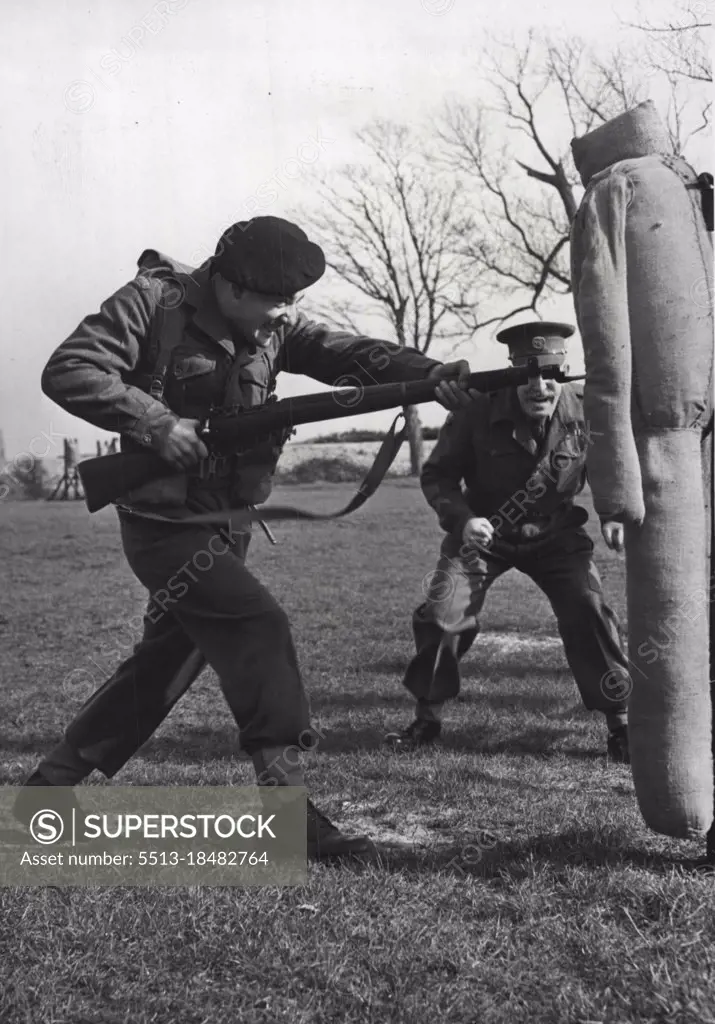 Soldiers In Training -- Spurred on by his instructor Q.M.S.I. Mackenzie, one of the senior instructors at the School, Pte. Brian Hulbert from Chippenham (Wilts) is seen engaged in bayonet practise during training in the small Arms Wing of the School of Infantry, Hythe (Kent). The Small Arms Wing of the School of Infantry at Hythe (Kent), is a development from the old School of Musketry. It's main purpose is the training of picked N.C.O.'S and Privates, both Regulars and National Servicemen, for an intensive course in the handling of all the small arms, which a modern infantryman may be called upon to use. April 28, 1954. (Photo by Fox Photos).