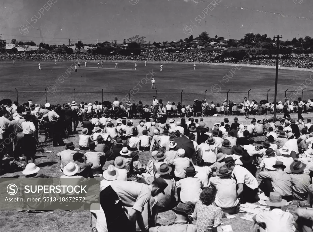 Barrackers is shirt sleeves, and poinciana trees fringing the outer, give Woolloongabba Oval a tropical air.Brisbane cricket enthusiasts are not catered for at The Gabba in the pretentious style of those in other capitals, but they can watch the game in coatless comfort under a hot sun. February 24, 1949. (Photo by The Telegram Newspapers Co. Ltd.).