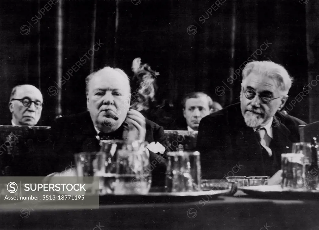 Churchill Concentrates On European Union Inaugurates Hague Congress.The Hague - Smoke curls from Winston Churchill's fat cigar as, seated behind water carafe and glasses, he apparently concentrates on the speech he was to deliver at the inaugural meeting of the Congress of Europe in the hall of knights in the Dutch capital with him is the former socialist premier of France, M. Paul Ramadier.Churchill was wildly acclaimed by delegates of 23 nations including the 16 in the Marshall Plan - when he called for the immediate establishment of a European Assembly and asked: 'Shall so many millions of humble homes in Europe sit quaking in dread of the policeman's knock' The Congress, he declared, must be a movement of peoples not of parties -"it must be all for all'. May 08, 1948.