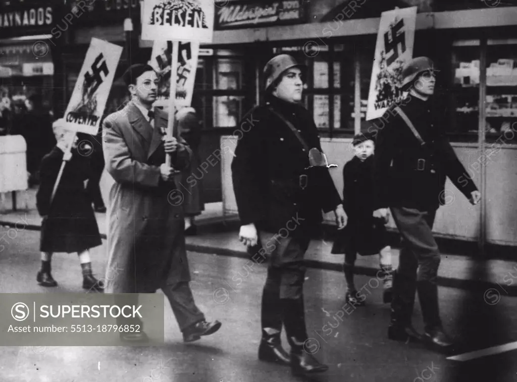 'Nazis' Strut Through Scarborough -- On the eve of the Socialist Party conference, steel-helmeted 'Nazi Storm Troopers' jack-boot their way through Scarborough, Yorkshire to-day (Sunday) in a procession arranged by the West Yorkshire Peace Organization as a 'welcome' ***** delegates.Some 200 women ***** children headed the procession, ***** which the black cross of the ***** regime mingled with banners ***** the names of notorious ***** camps. One banner ***** 'Don't arm the Nazis.' September 26, 1954. (Photo by Reuterphoto).