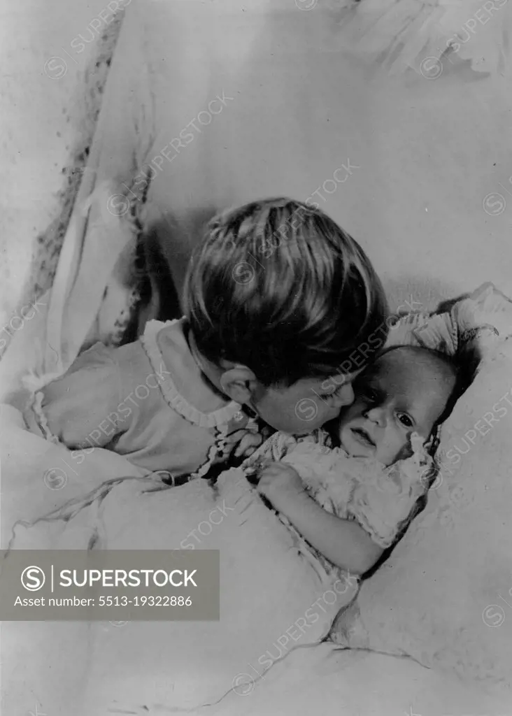 The first photograph taken of the two children of Princess Elizabeth and the Duke of Edinburgh. In this delightful study made by Cecil Beaton at Clarence House, London, Prince Charles, who will be two years old in November is seen leaning over to kiss the face of his month - old sister Princess Anne. The official title given to the new baby is Princess Anne Elizabeth Alice Louise of Edinburgh. May 15, 1953.
