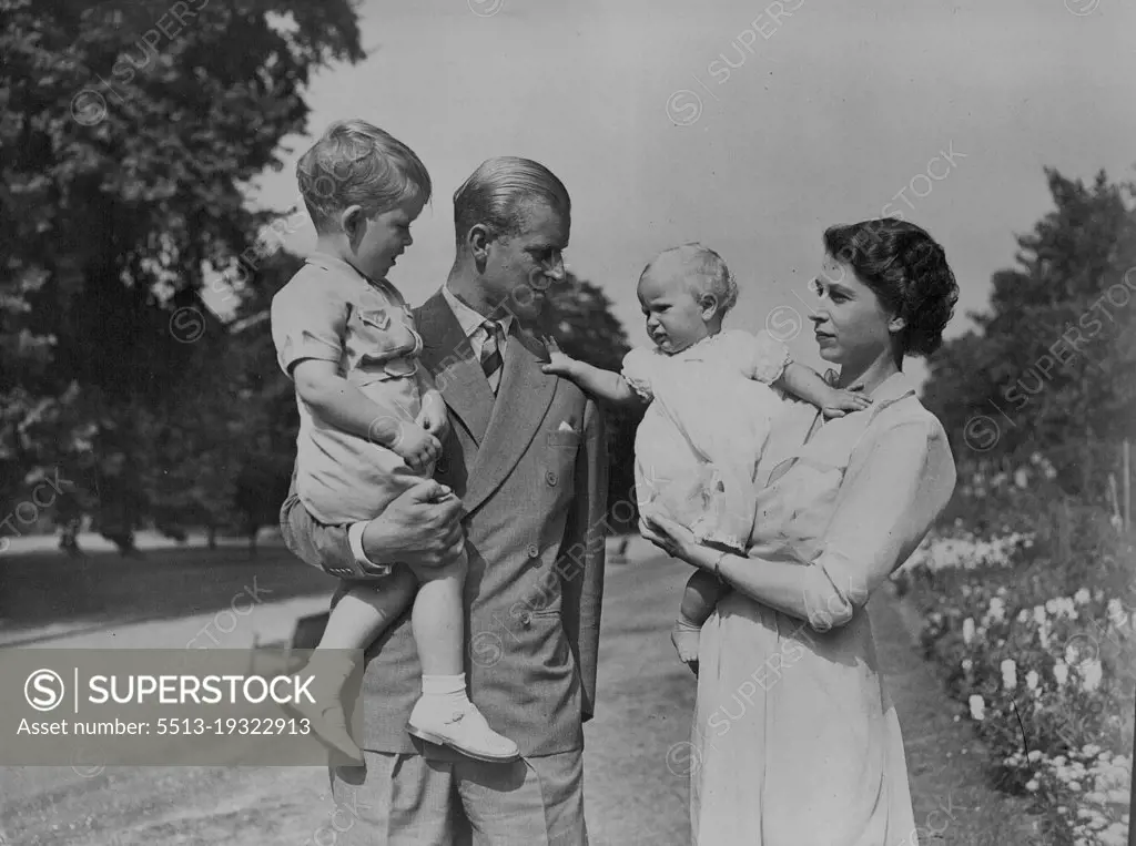 The Happy Family In Their Garden -- Princess Anne, held by her mother Princess Elizabeth, appears to be wanting to go to her father the Duke of Edinburgh who is holding Prince Charles.Pictures just released show H.R.H. Princess Elizabeth and the Duke of Edinburgh with their children Prince Charles and Princess Anne in the garden of the London Home Clarence House. August 09, 1951. (Photo by Barratts Photo-Press-Agency).