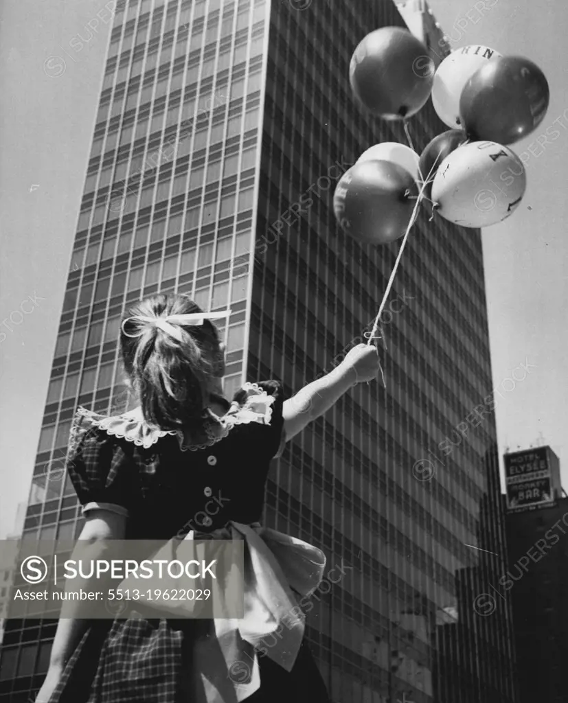Variations On A Theme - A front view of the building taken from streetlevel at a slight angle contains the added attraction of a little girl holding her balloons as she gazes upward. July 8, 1953. (Photo by United Press).
