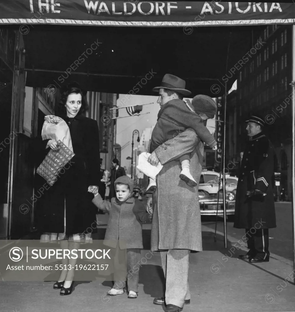 From A Cold Water Flat To The Waldorf -- Richard Earl Cox Carrier his sleeping 1½-year-old Son, Richard, Jr., As he, his wife Eleanor, and their other son, Jimmie, 2½, arrive at the Waldorf-Astoria Hotel, New York, March 14. Cox moved his family into a $12.60 a day room at the Hotel, insisting he would pay $4 of the monthly bill. The remainder. He said, would be sent to Mayor O'Dwyer because the city had not providing the Coxes with quarters in a veteran's housing project. The family was living in a $16 a month cold water flat in Brooklyn. March 14, 1948. (Photo by Associated Press Photo).