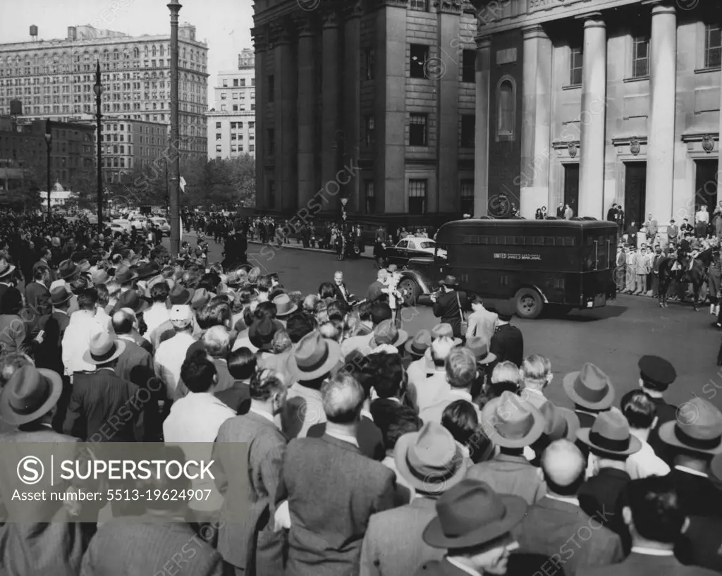 Off They Go -- A U.S. Marshal's van passes Federal Courthouse (center background), in New York City, Oct. 14, carrying 11 leaders of the Communist Party in the United States, following their conviction of conspiracy to teach the overthrow of the U.S. Government by Force. A crowd standing in Duane Street mixes cheers and jeers as the van moves from the courthouse garage towards Foley Square. October 14, 1949. (Photo by Associated Press Photo).