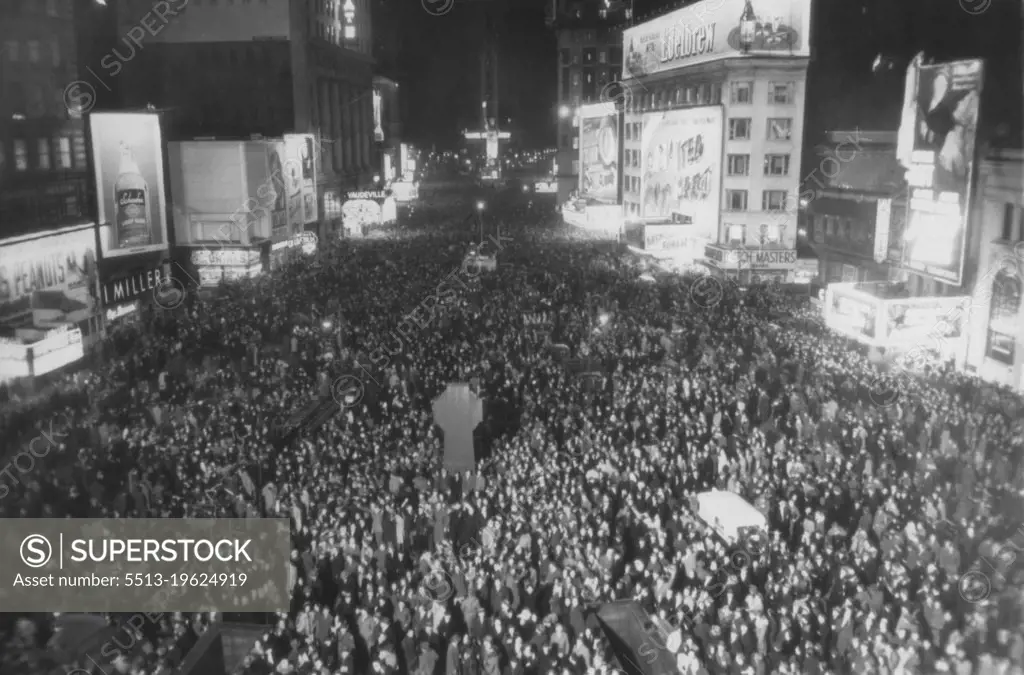 New York Greets New Year - This photo of jam-packed Times Square was made at exactly midnight as New Yorkers gathered to greet the New Year. The view was made from Broadway and 47th streets, looking south. January 01, 1945. (Photo by AP Wirephoto).