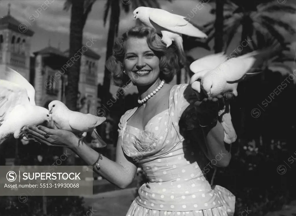 "Joan Finds Peace In Seville" -- In sunny Seville Joan found contentment - and she found these doves, the symbol of peace and a good omen for her future. December 19, 1955. (Photo by Sunday Mirror).