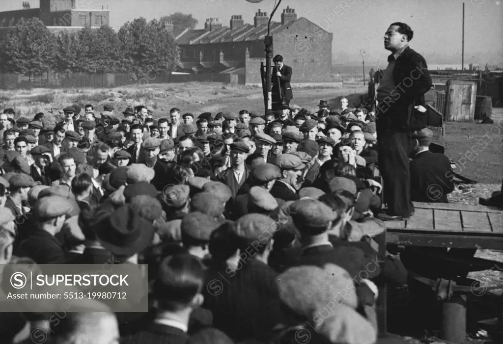 Dockers Hear 'Leader' On First Day of Emergency -- Crowd of London dockers listen to a speech by Albert Timothy, member of the unofficial 'lock out committee, at Royal.Victoria Dock to-day (Tuesday), first day of the State of Emergency regulations in the Port of London. More than 10,000 men are idle at the docks, and 112 ships are held up, owing to the refusal of the men to work the Canadian ships Beaverbrae and Argomont, which have been involved in a Canadian seamen strike. July 12, 1949. (Photo by Reuterphoto).