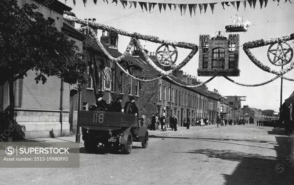 The Belfast Riots; Troops Called Out -- A police truck passing under the welcoming sign of the 12th July Orange Day arch in Belfast today, July 14.Troops were called out in Belfast last night, July 13, when rioting between Unionists and Nationalists, which began on Friday, flared up again. Today, July 14, the city was still patrolled by a thousand soldiers and policemen, and armoured cars, and every precaution is being made, for two people were killed and 60 injured in the previous night's riots. July 14, 1935. (Photo by Associated Press Photo).