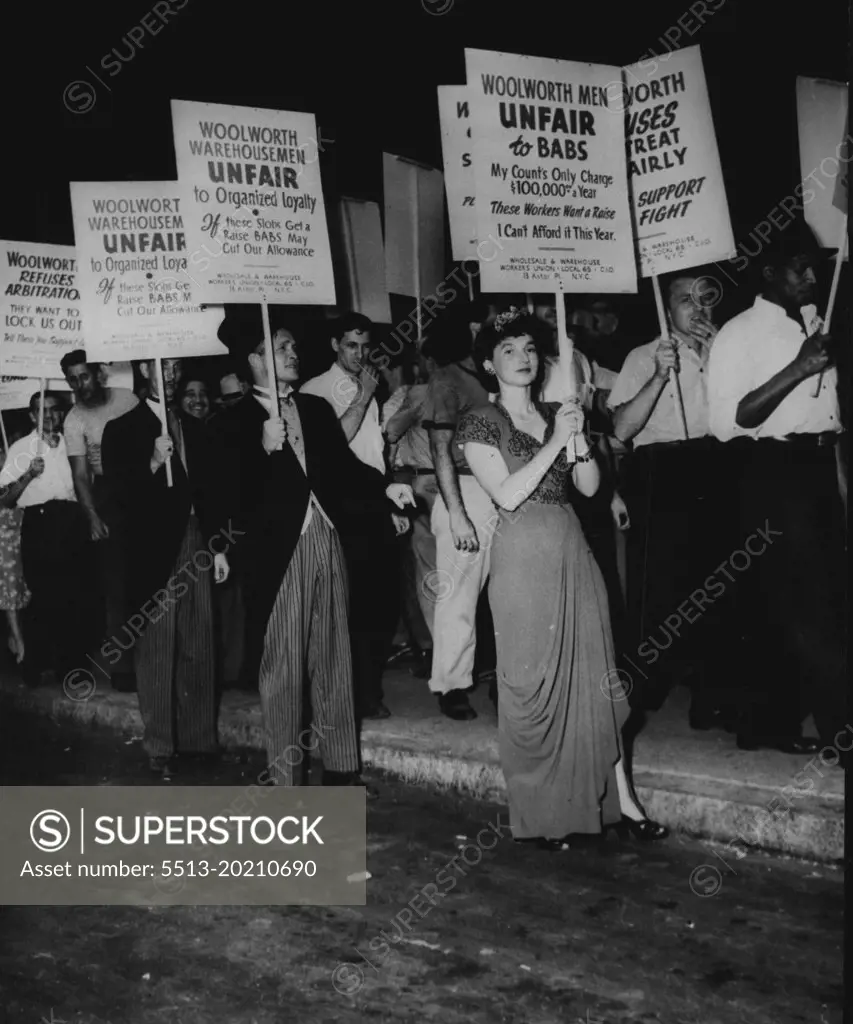 "Babs Hutton" Take off By Woolworth Pickets -- Woolworth warehouse employees and members of local 65, wholesale and warehouse union, picket the Woolworth Building in New York City, June 30, demanding re-signing of the union contract. The girl in evening gown is doing a takeoff on heiress "Babs" and men in striped, trousers and frock coats picket the pickets. July 22, 1947. (Photo by Associated Press Photo).