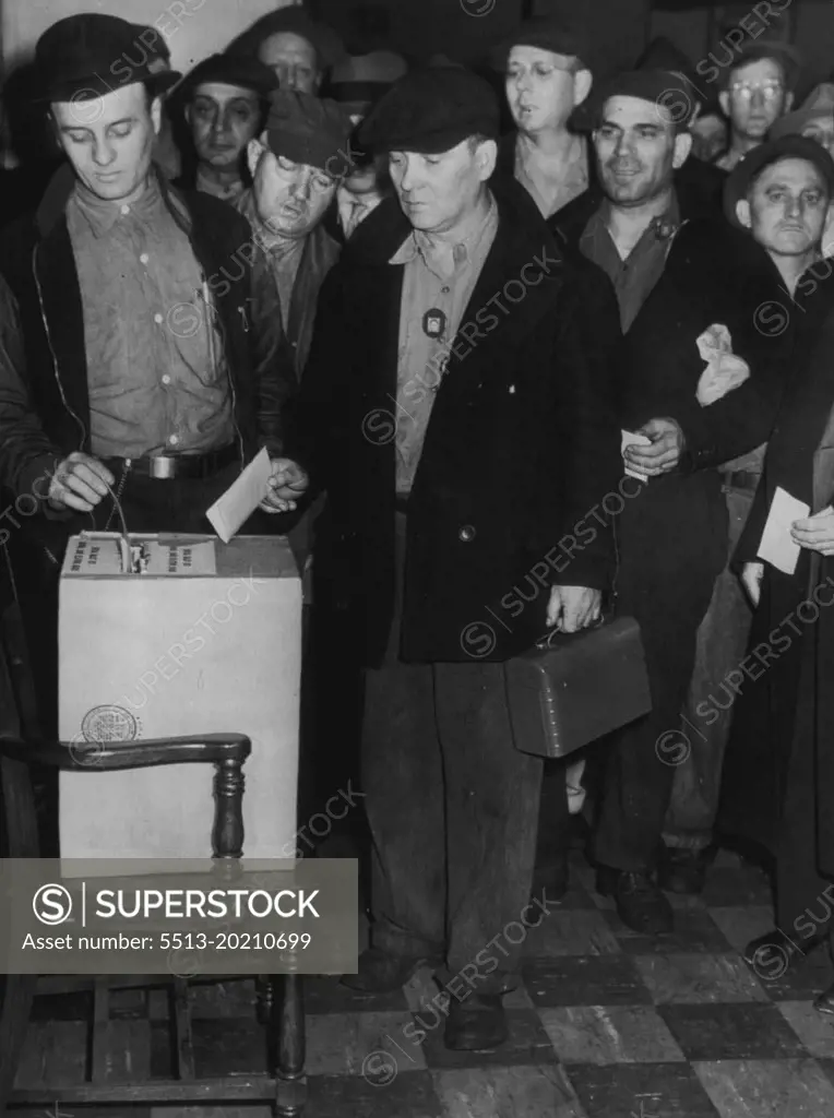 Ford Employees Take Strike Vote : Employees of the Ford Motor Co. Here, shown depositing ballots today, the last of the strike votes in the automobile industry's big three over a 30 per cent wage rate increase demand. Voters are members  of the United Auto Workers Union (CIO). November 7, 1945. (Photo by AP Wirephoto).