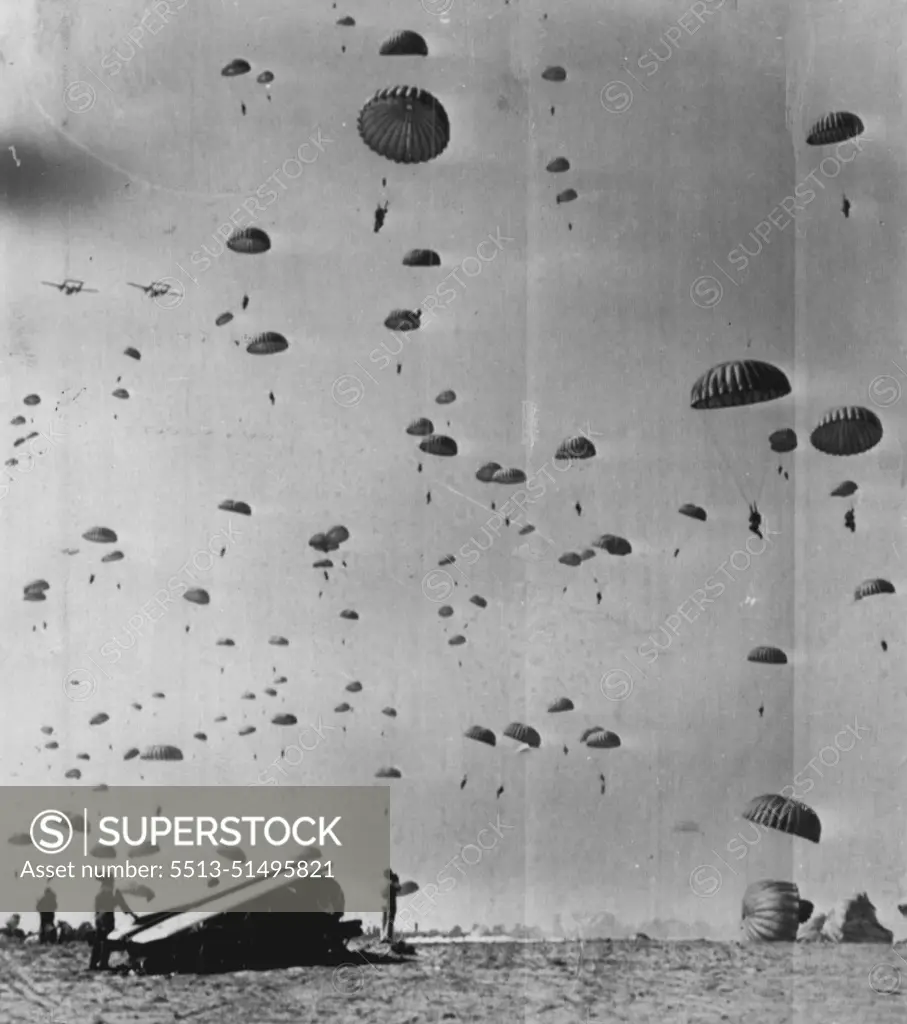 D-Day Drop - Troop of the 11th Airborne Division hit the silk over a drop zone here today as Exercise Swarmer. Army air invasion maneuver, gets underway. Object in foreground is a 105mm howitzer, dropped just before the men with a 100-foot-parachute, landing upside down. April 28, 1950. (Photo by AP Wirephoto).