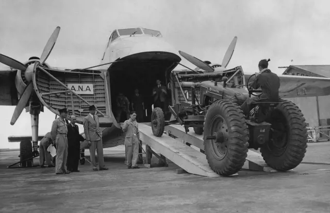 Huge Road Grader, weighing 9264lb., being driven into an ANA Bristol airfreighted at Essendon today for transport to Flinders Island. The grader is the heaviest single lift ever made by air in the Commonwealth. January 11, 1950.
