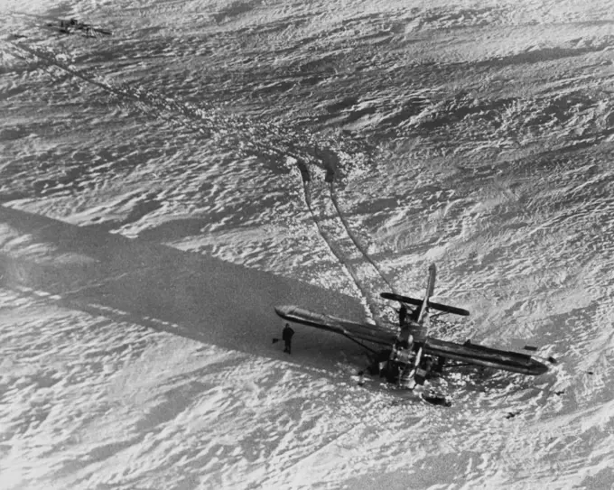 Evidence of A Rescue That Failed -- Several of the 11 Air Force men stranded on the Greenland icecap stand by the glider in which an attempt to rescue them was made by a C-54 making a "snatch" pickup of the glider tow rope. Attempt failed when glider plowed into deep snow causing tow rope to break. Further attempts to rescue men have hindered by stormy weather. December 23, 1948. (Photo by AP Wirephoto).