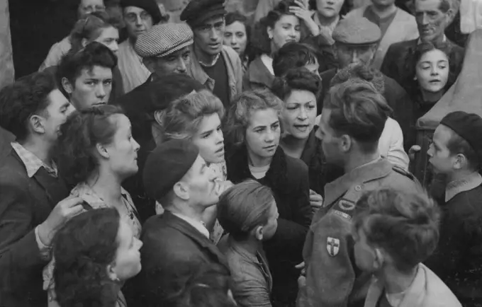 News For Caen Townspolk -- Citizens of Caen eagerly gather around Pierre Lefevre, the French Commentator of the B.B.C. for the latest news after the town was taken by British and Canadian Troops. September 11, 1944. (Photo by Associated Press Photo).