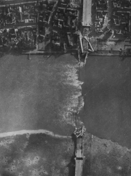 R.A.F. Attack On Cologne Of 28/10/44. Another RAF. reconnaissance picture taken after the attack of 28/10/44. Shows the large highway suspension bridge which was completely demolished. Cologne, worst damaged city in the whole of the Ruhr and Rhineland, was given its heaviest attack of the whole war by RAF. Bomber Command in the daylight attack of 28/10/44. Lancasters and Halifaxes dropped a great weight of high explosives and incendiary bombs on the railway and industrial city. The bombers were 