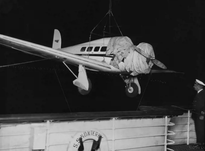 Fastest 'Plane In Australia -- Unloading a Lockheed Orion, capable of 220 m.p.h. from the liner "Monterey" at midnight last night. This machine, flown by Captain J.P. Dickson, accompanied by Mr. Arthur M. Loew, First Vice President Metro-Goldwyn Mayer Pictures, and Mr. Rosthal, will fly to Melbourne Saturday, Adelaide Monday, Wyndham Tuesday, thence depart on the biggest commercial world flight yet undertaken. Vacuum Oil Company have arranged supplies. Lights of Sydney harbour bridge can be seen