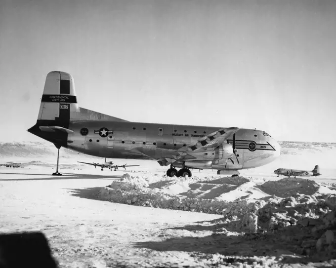 Resupply Transports. A Military Air Transport Service C-124 Transport plane dwarfs two 4-engine C-54s used in airlifting supplies and equipment to personnel building the air base, at Thule, Greenland. September 18, 1952. (Photo by Official Air Force Photo).