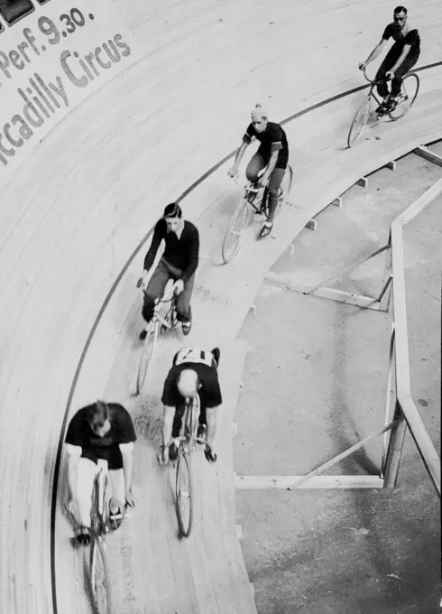 The First International Six-Day's Bicycle race in London started at Midnight, July 15th., On a specially constructed track at the Olympia, London. The riders - many of whom are competitors from several countries - will eat and sleep in full view of the spectators. The track is banked to an angle of 52 degrees, and takes eight laps to the mile. Some of the competitors taking it easy at the bottom of the track during a lull in the sprinting. July 16, 1934. (Photo by Sport & General Press Agency L