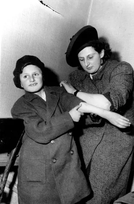 Mother And Son Reunited By Nazi Brands - They now Speak Different Languages -- Mrs. Ruth Friedhoff and her son, Peter Dattel, compare the identification numbers branded on their arms by the Nazis. The boy was traced by the number. Reunited by the identification numbers branded on their arms by the Nazis, a mother and child separated for years by suffering and now speaking different languages are together again in Berlin. They are Mrs. Ruth Friedhoff and nine-years-old Peter Dattel. Peter's fat