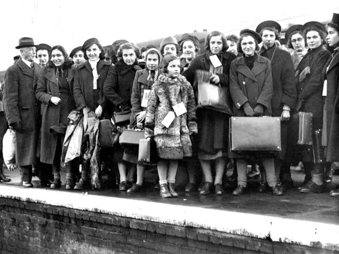 Jewish Refugee Children Arrive -- The refugee children photographed on arrival at Lowestoft yesterday showing the smallest arrival in centre in fur coat. Over 500 Jewish refugee children mostly from Vienna arrived at Lowestoft yesterday. They are being accommodated at the Pakefield holiday camp, Lowestoft. Their ages range from 10 to 17 years with the exception of one little girl who is 7 years of age. Their first real meal for two days consisted of kippers given by the Lowestoft herring Mercha