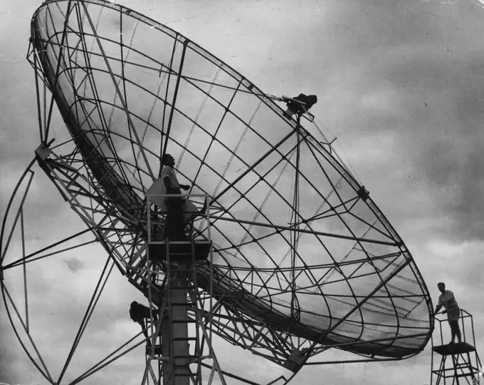 Workmen making final adjustments to the giant radio telescope at the radio physics station of the C.S.I.R.O. at Potts Hill, near Bankstown, yesterday. Scientists at the station hope that the telescope, in conjunction with a similar unit working in Holland, will locate the cause of interference to short-wave radio transmissions. December 16, 1954.