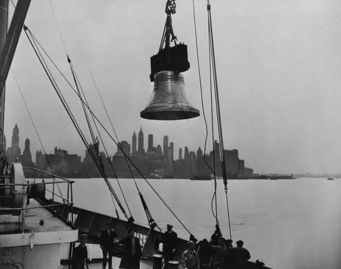 One of the 13 bells being unloaded from the steamship Excalibur at Jersey City, New Jersey. In background is the skyline of New York City. Thirteen replicas of the Liberty Bell, the first shipment of 52 to be used in connection with the Independence Savings Bond campaign of the U.S. Treasury Department, arrived recently (April 21, 1950) in the United States from Annecy, France, where they were cast. During the 6-week campaign, which begins May 15, 1950 and ends July 4, 1950, the bells will be ex