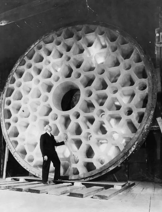 World's Largest Telescope -- John L. Thomas, treasurer of the Corning glass works, contemplates the world's largest piece of glass, the 200-inch telescope disc now being prepared for shipment from corning to California. February 22, 1936. (Photo by Associated Press Photo).