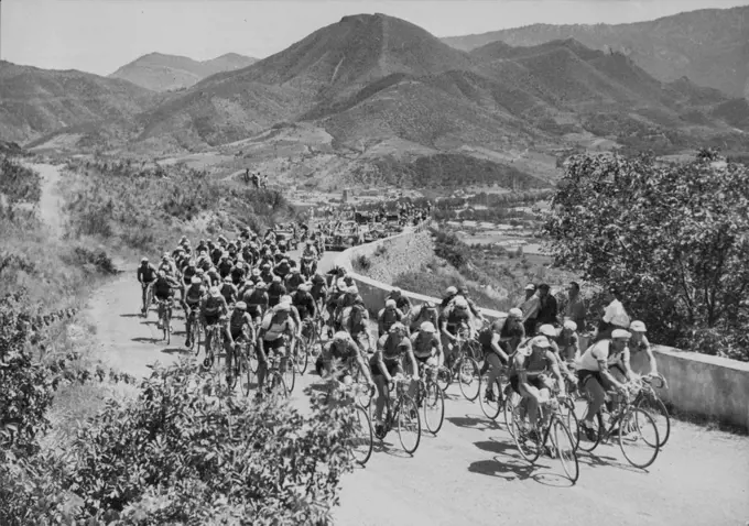 A typical scene in the Tour de France in one of the more restful periods with the field making its way slowly in rugged country. The Tour De France Cycling - the pack in the first slopes of the Pyrenees. August 24, 1953. sports, sport, athlete, athletic, 