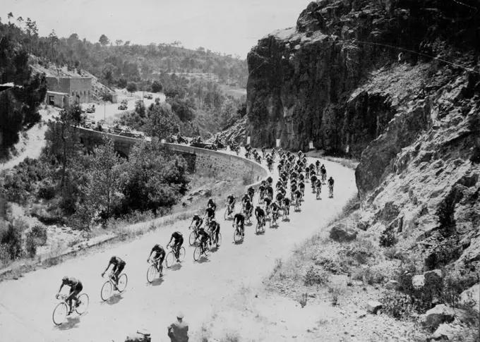 One of the many mountain climbs which make "Le Tour" a back-breaking assignment for competitors. Having a French mountain village Tour de France competitors string out over a winding road on yet another stage of the 25-day ***** 3000 miles race. October 24, 1950. (Photo by Sports And General Press Agency Limited). sports, sport, athlete, athletic, 