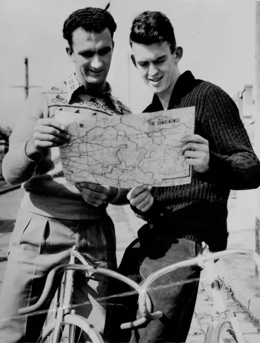 NZ Riders Train Here - Champion NZ amateur cyclists Les Lock (left) and Colin Dickinson plan their morning training ride before they set out for a tour of the Dandenongs today. The visitors are here for experience and will ride at the opening of the board track on Saturday week. October 22, 1951. sports, sport, athlete, athletic, 