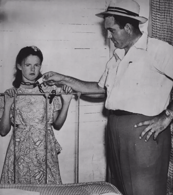 Farm Wife Says She Was Chained -- Blanch Hamby (left) 21-year-old farm wife, shows State Investigator San Allen the position in which she says she was often chained to the foot of her bed during the two years sine her marriage to Lester Bamby, 38. The husband is in Tallapoosa county jail charged, with assault with intent to murder and assault and battery. September 17, 1948. (Photo by AP Wirephoto).