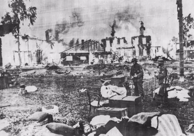 German In Leningrad Suburb -- German Soldiers stand in the Midst of Household possessions Abandoned by the fleeing residents of a Leningrad Suburb, According to the German Censor-Approved caption. In the background are Russian homes set Ablaze during the German siege of the second city of the Soviet Union. Photo was flashed to New York from Berlin today by Radio. September 23, 1941. (Photo by German Official Photo). 