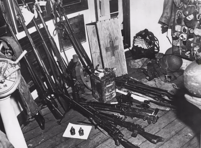 Contraband: Rifles and hand-grenades found by searches on the Tachihama Maru. Grenades are on the white sheet on the foreground and in the tin at rear. August 17, 1945.