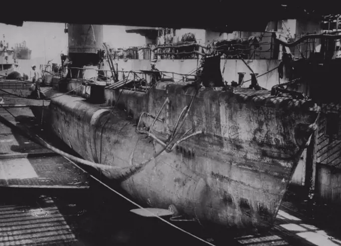 Captured Jap Sub Reaches U.S. -- A captured Japanese cargo submarine, 137 feet in length, is shown aboard ***** LSD which brought it here for repairs and display. It was found ***** abandoned in Lingayen Gulf. June 04, 1945. (Photo by AP Wirephoto).