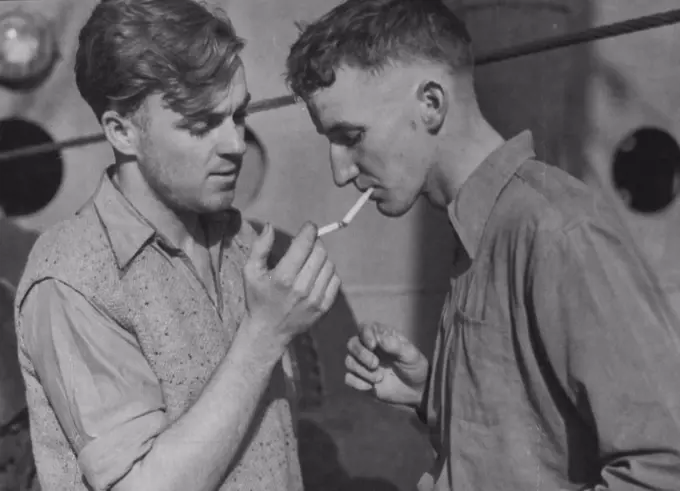 Fourth Engineer Bruce Miels and George Fisner, deck by on the torpedoed Australian ship, enjoys a smoke after being landed in port. Thirty-seven sailors lost their lives when the ship sank in 30 seconds. June 4, 1942. 