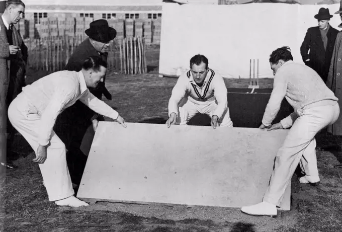 A New Concrete Cricket Pitch -- Left to Right: Len Muncer, of Glamorgan; Bill Edrich, England and Mieddlesex; and Eddie Ward, of the Chiswick school demonstration the easy laying of the concrete sections of the pre-cast cricket pitch. March 04, 1949. (Photo by Sport and General Press Agency Limited).