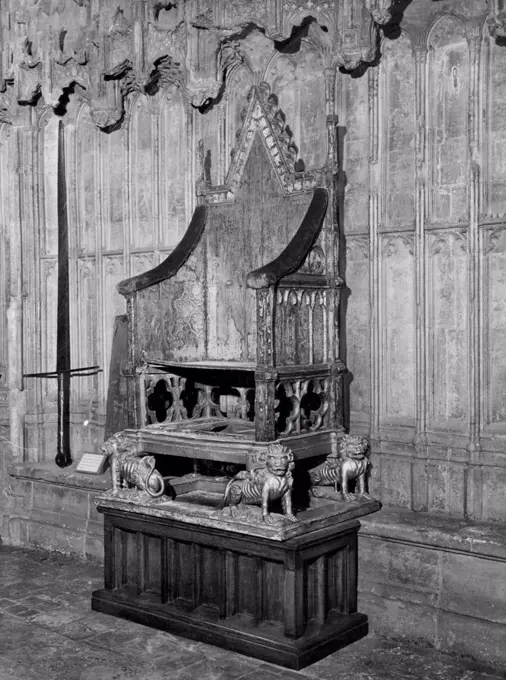 The Coronation Chair - furniture at its most architectural. ***** Chair in Westminster Abbey, which is representative of furniture at its most architectural. That chair, on which our Queen was crowned, was made by Master Walter of Durham to the order of Edward I to hold the Stone of Scone, which he brought from Scotland in 1296. It was originally brightly painted, and later gilded: seven layers of paint have been found on it. The four lions at the base were added for the coronation of Henry VIII. January 30, 1951. (Photo by Daily Mail Contract Picture).