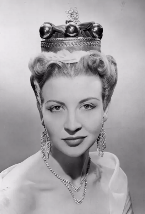 A baroness' coronet rests securely on this foundation, dressed high in front; at the back hair is cut one to two inches long, set in tight curls and then brushed out thoroughly. July 3, 1952. (Photo by Odhams Photographic Studio)