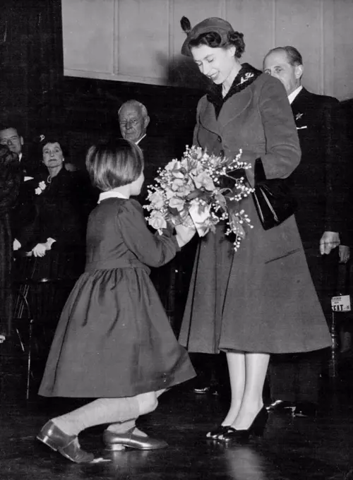 The Queen Visits Girls' School -- Rosemary Kidson, 8, of Leeds, Yorkshire, presents a bouquet to Queen Elizabeth II as Her Majesty arrived at this Royal Masonic School for girls at Rickmansworth, Hertfordshire today March 11. The Queen paid a two-hour visit to the school. There was loud applause when the headmistress, Miss A. Fryer, told the 400 girls that the Queen had asked her if she would allow them an extra day's holiday. March 22, 1955. (Photo by Associated Press Photo).