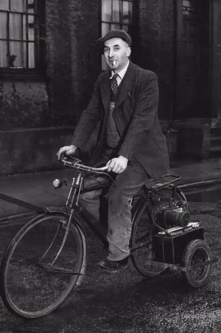 No "Basic" Needed -- Mr. Bullock on his electric cycle. It is absolutely noiseless, climbs steep hills, and has only one fault - it develops too much speed to easily on the flat! Determined not to be deprived of mechanical locomotion by the abolition of basic petrol, Mr. Tom Bullock, of Berrington street, Herreford, has devised a method of transport which will be envied by errand boys. It is an electric bicycle driven by a 12 volt car battery. He bought a second-hand bicycle, fixed a small carriage on it to carry battery and starter-motor; the machine is chain driven, has lights and a born powered off the same battery. January 13, 1948. (Photo by Fox Photos).