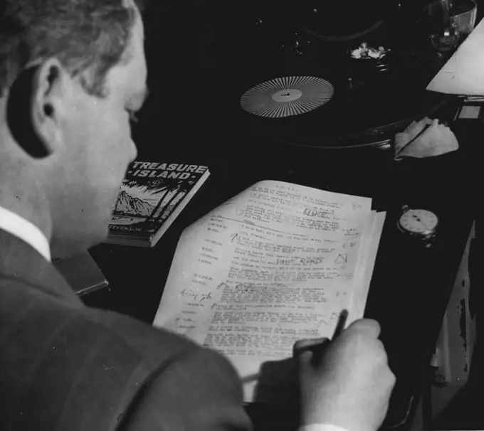 Paul Jacklin, Production Manager of 2UE, listens to rehearsal of Treasure Island marks script to remind himself where alterations in actors portrayal of role. July 6, 1951.