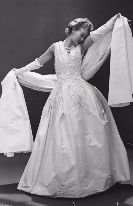 This exquisite Dior ball gown is in heavily embroidered white faille with matching faille stole. January 10, 1955. 