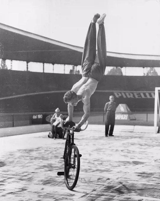 Going Around In Cycles - "Look, MA, No Feet!" Yugoslav cyclist Stanislav Vakulic does a variation of the no hands routine during the recent world cycling championships held near Rome. He works up a good pace and then stands on the handlebars and saddle on his hands. September 23, 1955. (Photo by United Press).