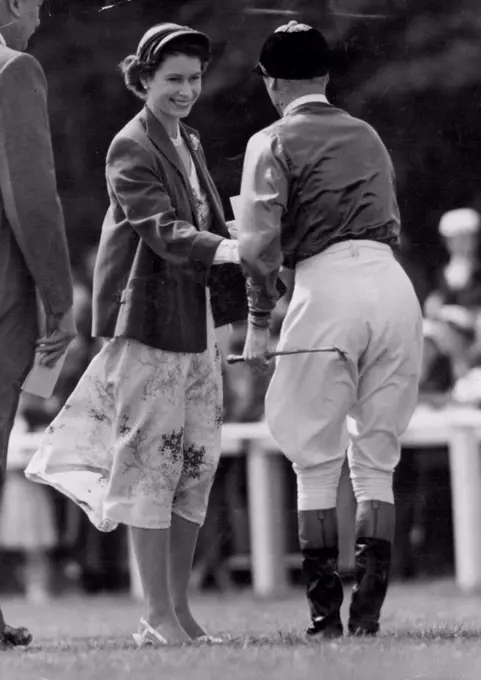 The Queen At Epsom Today -- Smiling radiantly, H.M. The Queen is seen wishing her jockey W.H. Carr "Good Luck" prior to the Oaks Stake at Epsom today, in which her filly "Angel Bright" was a runner. In today's bright sunshine Her Majesty wore a floral summer dress, with short jacket of emerald green and small matching hat. June 4, 1954. (Photo by Fox Photos).