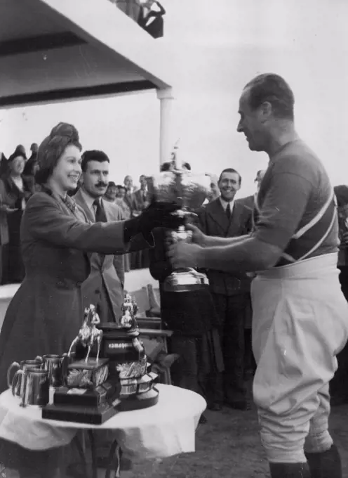 Princess Presents Polo Cup - Princess Elizabeth presents the Cownpore Polo Cup to Lord Mountbatten, Captain of the Shrimps team which beat the Saints in the final for the cup at Marsa, Malta December 2. December 06, 1949. (Photo by Associated Press Photo).