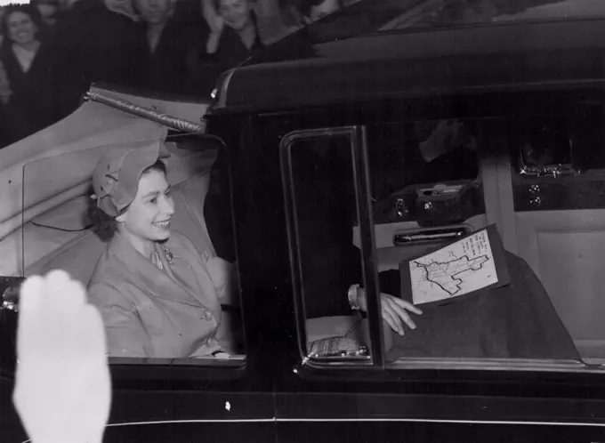 The Queen smiles as the crowds wave and cheer during the Queen's first Coronation drive through the London streets. The Royal Couple followed the route with the aid of a map seen on the Duke of Edinburgh's lap. June 03, 1953. (Photo by Daily Mirror).