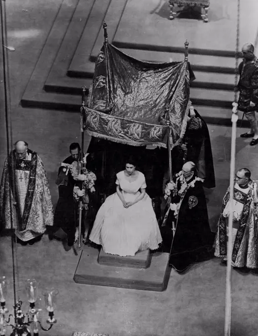 The Queen Awaits The Anointing -- Disrobld, the Queen sits in St. Edward's chair as four Knights of The order of The Garter carry forward the canopy which is to remain over the Queen during the ceremony of anointing. The anointing, on the head, the bread, and the hands, is carried out by the Archbishop of Canterbury. At left is the Bishop of Durham. At right is the Bishop of Bath and Wells. Pictured made in Westminster Abbey, London, June 2. January 06, 1954. (Photo by Associated Press Photo)